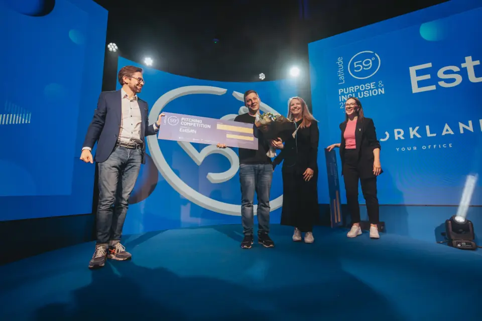 Nick Lahoika holding the Latitude59 Pitch Competition winner cheque on stage