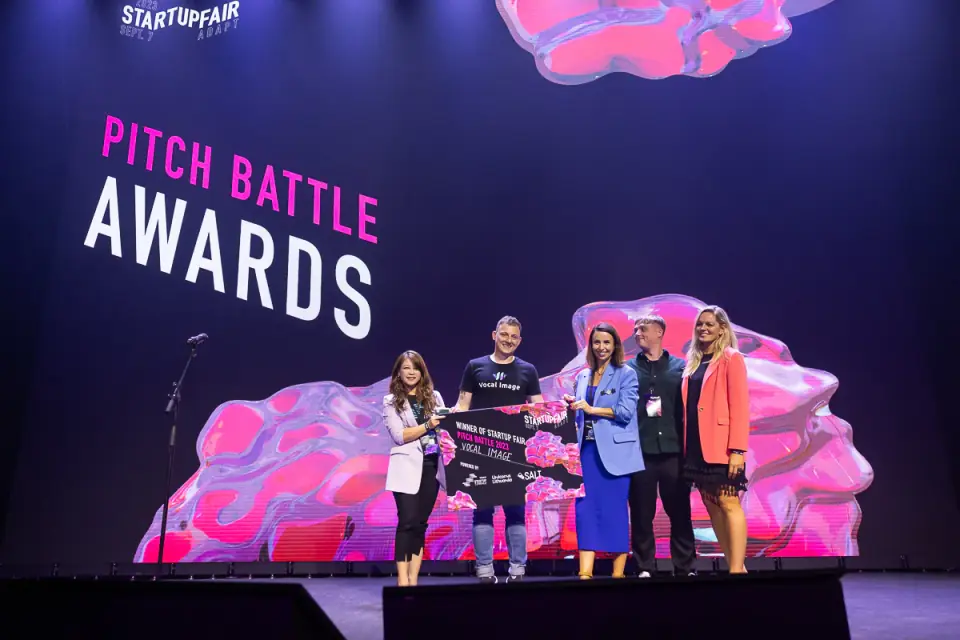 Nick Lahoika holding the Startup Fair Pitch Battle winner cheque on stage